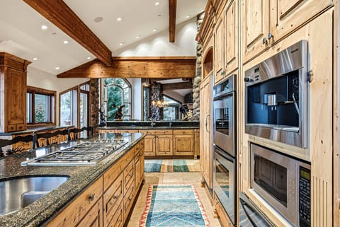 Gourmet kitchen with appliances:
Gourmet kitchen featuring stainless steel appliances, custom wood cabinetry, granite countertops, and vaulted ceilings.