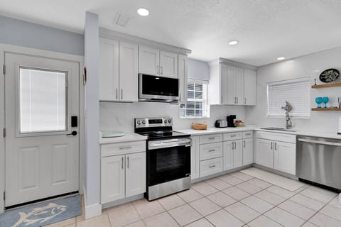 Fully equipped kitchen with fridge, oven, stove, microwave, toaster, coffee maker, basic cooking utensils, dishware, and more!