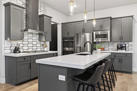 Sleek, modern kitchen with a spacious island, premium stainless appliances, and bar seating—perfect for casual breakfasts, après-ski bites, and group meals.