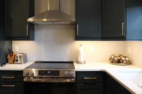 Kitchen - Stainless steel gas range seamlessly integrated into the kitchen’s granite countertops and oak cabinetry. Offers precise temperature control. Paired with a matching stainless steel oven.