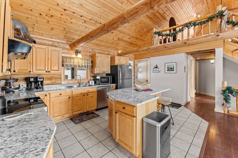 Spacious log kitchen with granite counters, stainless appliances, island seating