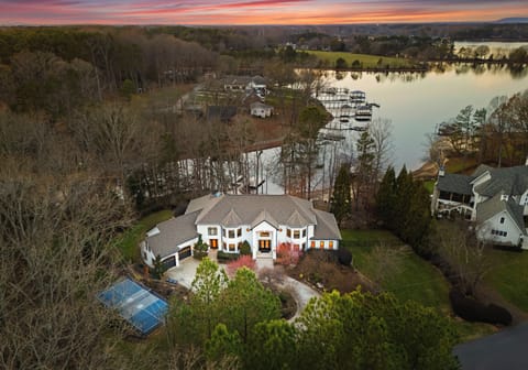 Aerial drone view of the luxury lakeside estate at sunset.