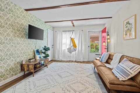 Relax in a bright living room w/ cozy sofa seating, TV & sunlight streaming through large windows