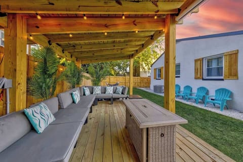Cozy covered patio w/ string lights & cushioned seating, perfect for relaxing evenings outdoors