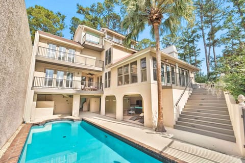 Stunning multi-level vacation home featuring private pool, palm trees, and spacious balconies surrounded by lush coastal forest.