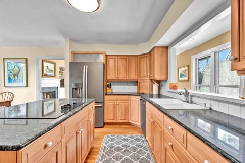 Your gourmet kitchen awaits with granite counters, stainless appliances, and warm wood cabinetry perfect for creating memorable meals together.