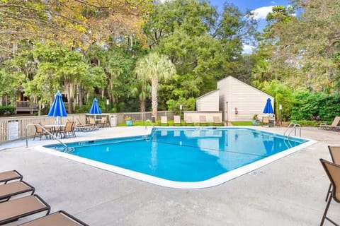 Dive into crystal-clear waters surrounded by lush landscaping and comfortable lounge chairs for your perfect poolside retreat.