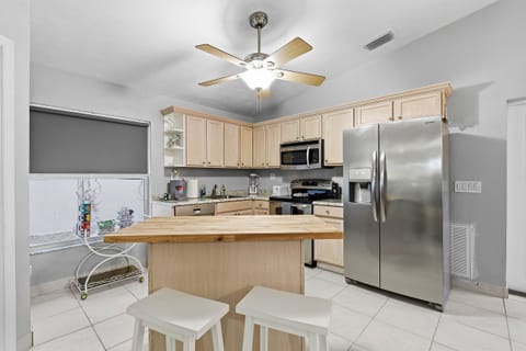 This beach stay kitchen features a central island with seating, modern appliances, and ample space—perfect for casual meals and gathering after a fun day at the beach.