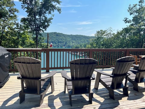 Upper level deck with lounge chairs and dining table and stunning views