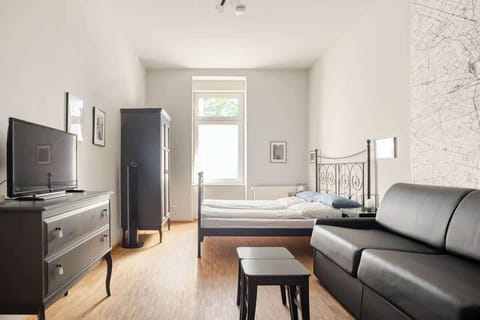 Das Zimmer hat ein Doppelbett und einen Couch-Bereich. Das Sofa lässt sich bei Bedarf zu einem zusätzlichen, komfortablen Doppelbett umwandeln. Durch einen mobilen Raumteiler lassen sich Schlaf- und Wohnbereich voneinander trennen.