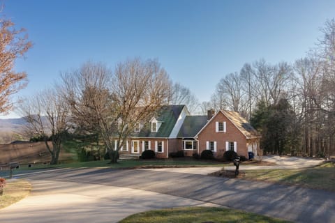 Admire the warm welcome of classic dormers and white shutters bathed in golden afternoon light.