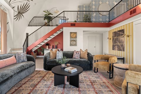 An airy, designer living space with vaulted ceilings, bold desert murals, and panoramic light—crafted for unforgettable stays.