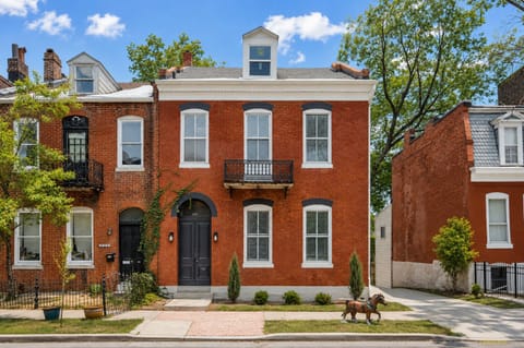Straight-on daytime view of the historic brick rowhouse exterior.