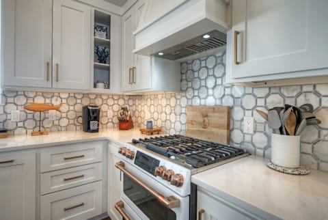 High-end kitchen stove with a decorative hexagonal tile backsplash.