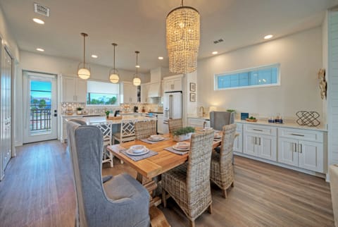 Kitchen and dining view showing the large blue island and breakfast bar seating.
