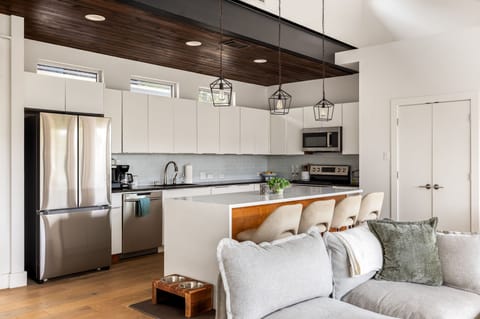 Fully equipped kitchen with stainless steel appliances and seating