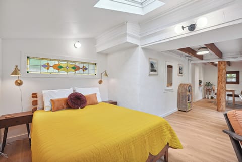 Queen bed with light from skylights overhead
