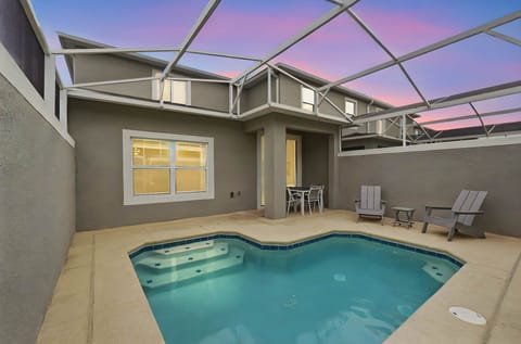 Private pool area with seating under a covered patio at sunset