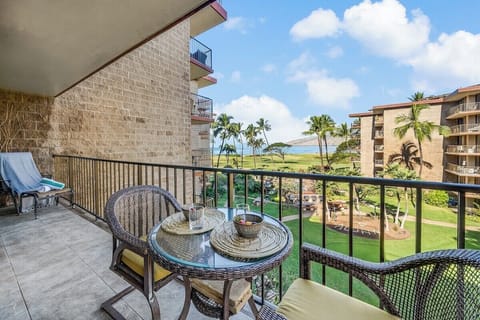 A charming lanai dining setup with tropical views overlooking the resort gardens and surrounding palms.