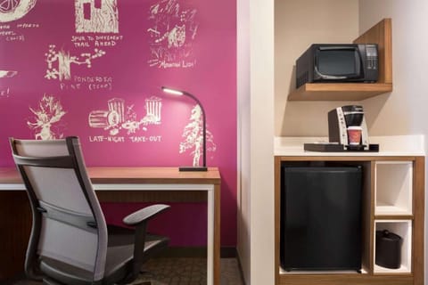 Workspace with magenta wall art, chair, and built-in appliances.