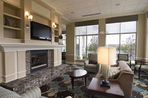 Lobby lounge with fireplace, sofas, and large windows