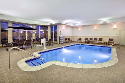 Indoor pool with tables, chairs, and bright lighting