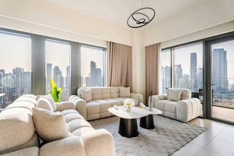 Elegant modern living room with plush seating, marble coffee table, and floor-to-ceiling windows showcasing stunning Burj Khalifa views. Enjoy a luxury hotel-style ambiance with a 75-inch Smart TV, perfect for relaxing in the heart of Downtown Dubai.