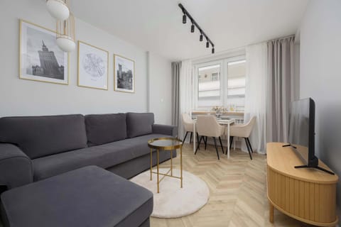 Bright living room with sofa, coffee table, and dining area.
