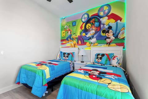 Disney-themed Mickey bedroom with twin beds and colourful accents