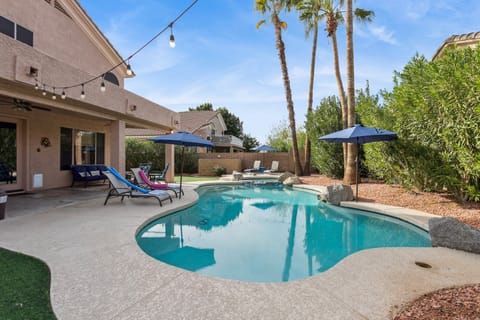 Dive into your private oasis with this sparkling pool surrounded by mature palms and string lights.
