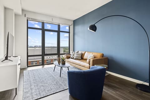 Recharge on the leather sofa beneath sweeping, modern lighting.