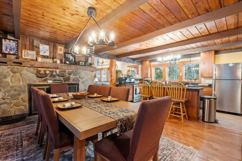 A spacious dining setup with forest views in every direction. Fireplace is not operational and only decorative
