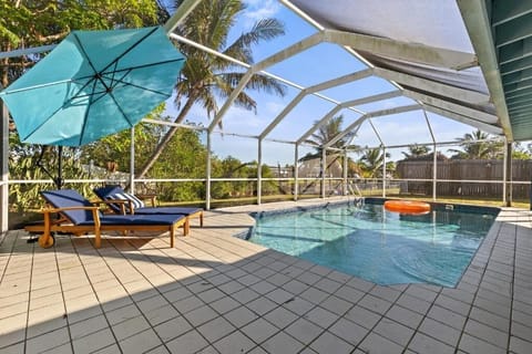 Screened pool patio with shaded seating and canal views