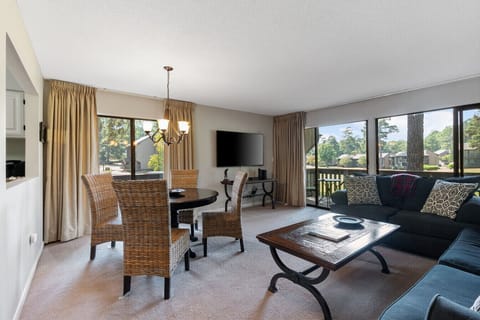 Dining area and living room with big windows overlooking the fairway.