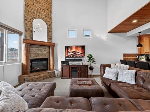 Cozy up in luxurious leather seating beside your crackling stone fireplace, where warm wood accents create the perfect mountain retreat atmosphere.