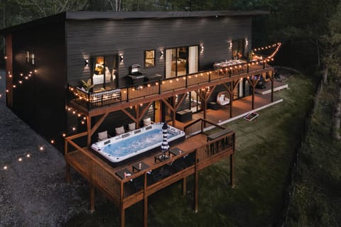 {Welcome} Nighttime at Summit House — soak in the swim spa on the elevated deck beneath glowing string lights, sharing stories over a glass of wine with mountain views all around. The perfect way to unwind and end the night.