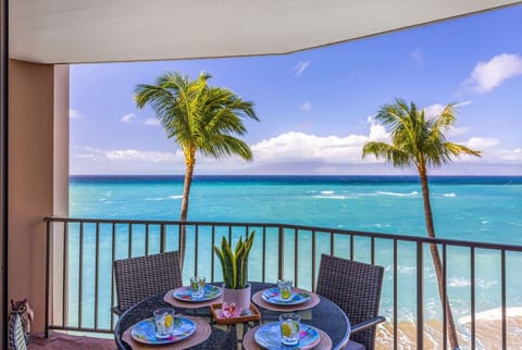 Dine on a private oceanfront lanai with swaying palms, turquoise water, and endless blue skies creating a stunning island backdrop.
