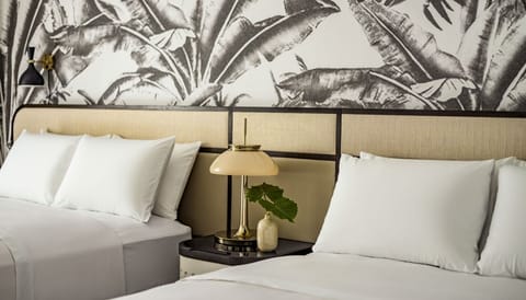 Drift off on cloud-soft pillows beside warm, ambient bedside lighting.