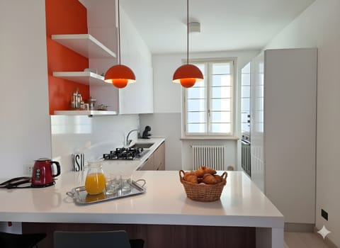 Modern and bright kitchen in the apartment located in Peschiera del Garda, equipped with a central island and fully equipped. The room has a stove, sink, appliances, and large countertops, ideal for preparing meals and enjoying convivial moments during your stay.