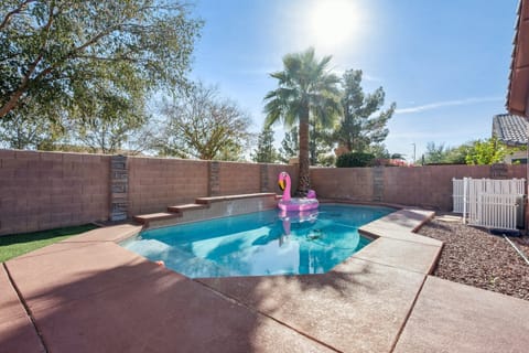 Your private pool awaits with crystal-clear water and fun flamingo float, surrounded by desert palms
