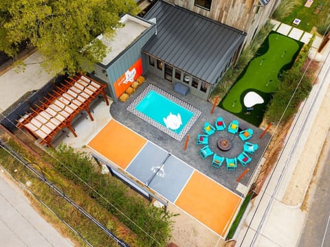 Enjoy your stay with a private pool, outdoor fire pit surrounded by colorful chairs, a fun putting green, and your own shaded lounge area — the perfect backyard oasis for relaxation and entertainment!
