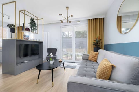 A spacious living room with a comfortable sofa, soft cusshion, and a coffee table, where natural light enhances the interior.
