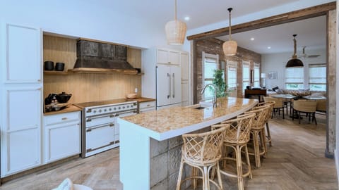 Gather around your gourmet kitchen island where rustic beams meet modern luxury, creating the perfect space for cooking and connecting...