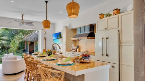 Your dream kitchen awaits with elegant marble island, tropical views, and everything needed to create memorable meals during your stay.