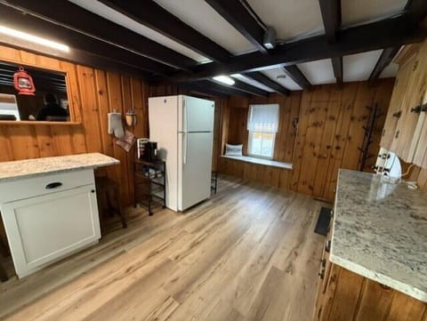 Step into your rustic kitchen featuring warm wood paneling, exposed beams, and modern appliances for home-cooked meals.