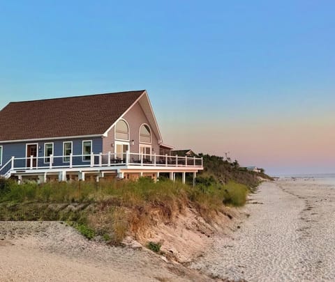 Escape to this stunning beachfront property. Perfectly situated on the shore, this home offers expansive decking for breathtaking ocean views, direct beach access, and the ultimate serene setting for a luxury coastal getaway.