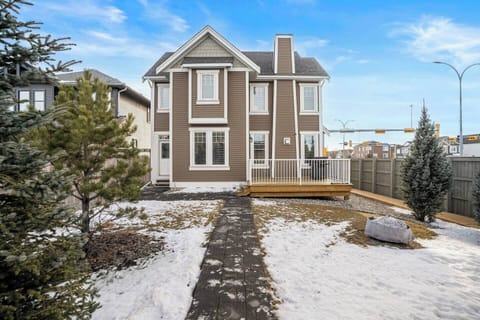 Backyard view of the Dynasty. The partially-fenced backyard features a double-car garage, wood-burning fire pit, a deck/patio space with a BBQ, and access to the lower-level suite.