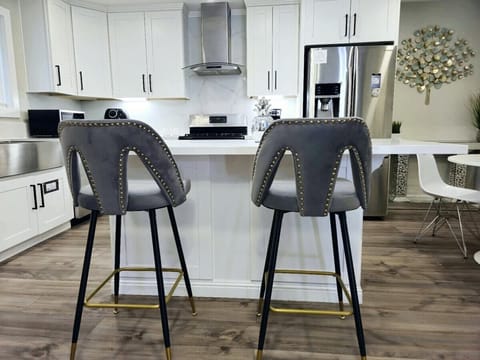 Modern open‑concept kitchen featuring a large island with stylish bar seating, white cabinetry, and stainless steel appliances. Designed for both functionality and entertaining.