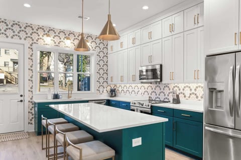 Designer kitchen with a large island, seating for casual meals, modern appliances, and a dining table for gathering together.