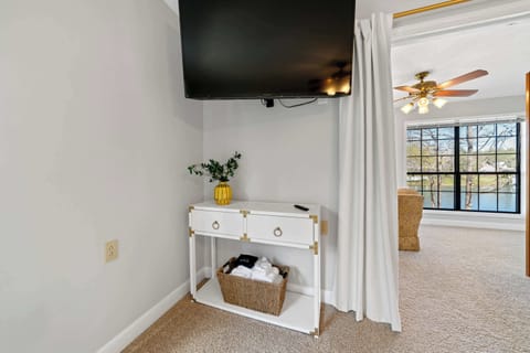 Spacious room with king bed, TV, and sunroom access.